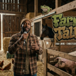 Man holding microphone in barn beside Farm Talk logo and animals